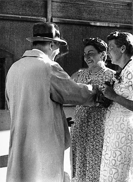Adolf Hitler speaks with two women in front of his apartment on Prinzregentenplatz in Munich